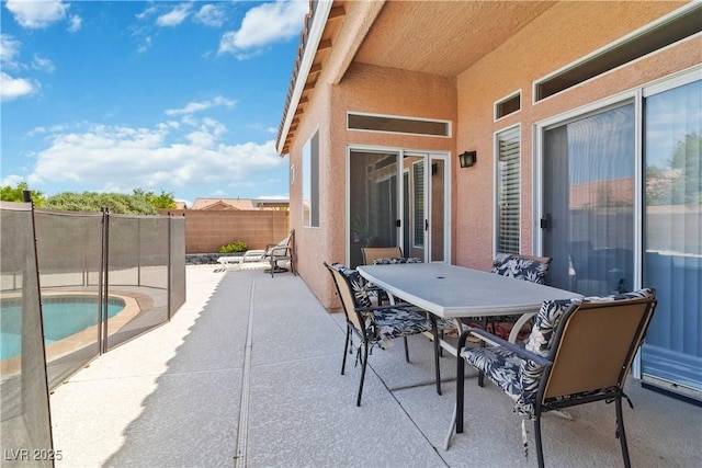 view of patio / terrace with outdoor dining space, a fenced in pool, and a fenced backyard