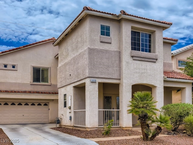 mediterranean / spanish-style home featuring concrete driveway, a tiled roof, a garage, and stucco siding