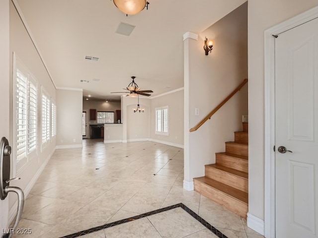 entrance foyer with baseboards, ornamental molding, ceiling fan, and light tile patterned floors
