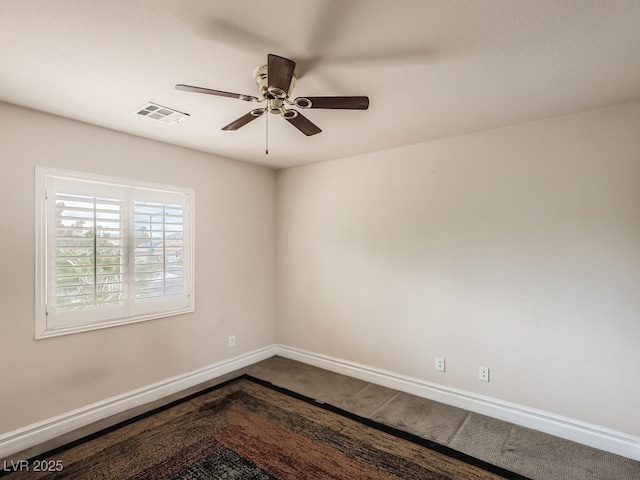 unfurnished room with visible vents, baseboards, ceiling fan, and dark colored carpet