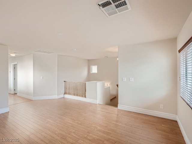 unfurnished room with baseboards, visible vents, and light wood-style floors