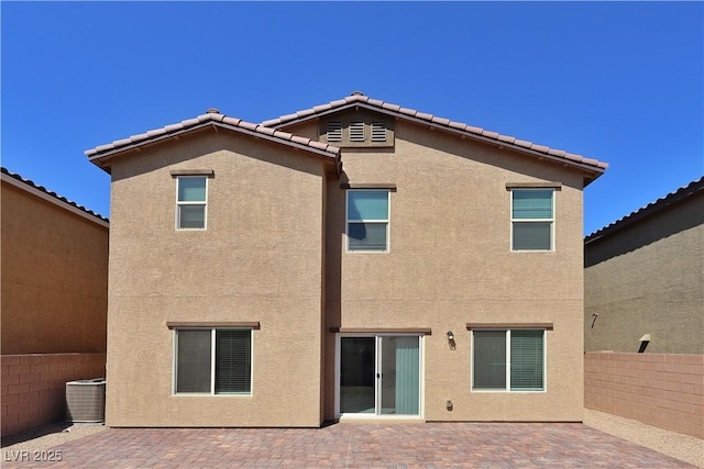 rear view of property featuring fence, cooling unit, a patio area, and stucco siding