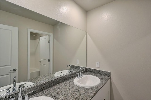 full bathroom featuring double vanity and a sink