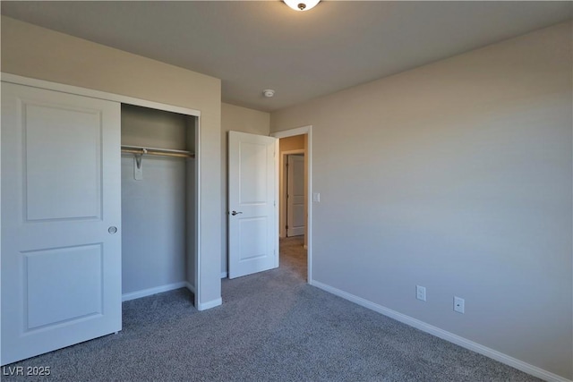 unfurnished bedroom featuring carpet floors, baseboards, and a closet