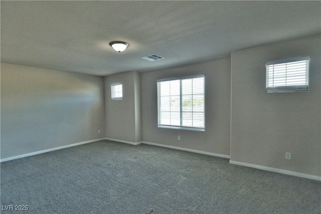 spare room featuring visible vents, carpet, and baseboards
