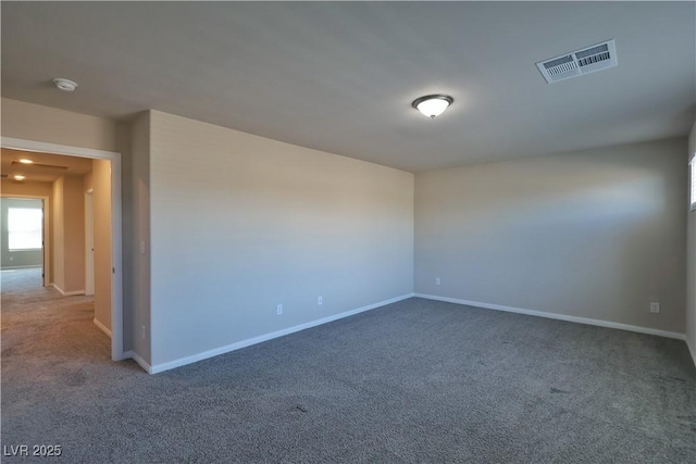 carpeted spare room featuring baseboards and visible vents