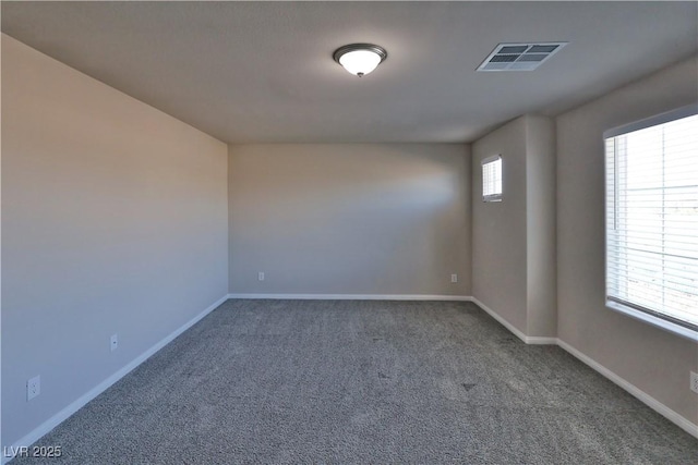carpeted spare room with visible vents and baseboards