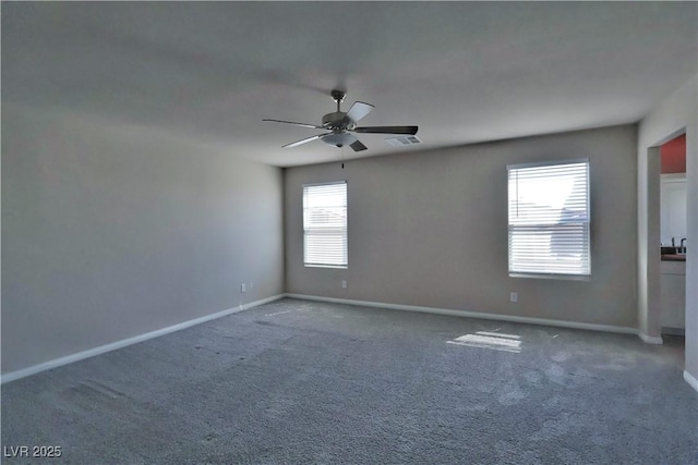 spare room featuring baseboards, carpet flooring, ceiling fan, and visible vents