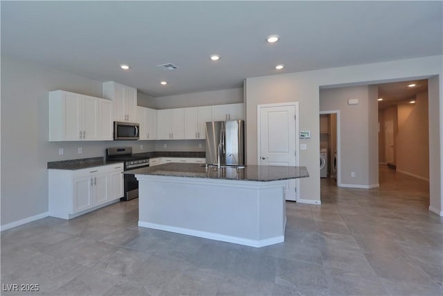 kitchen featuring visible vents, washer / clothes dryer, dark stone counters, white cabinets, and appliances with stainless steel finishes