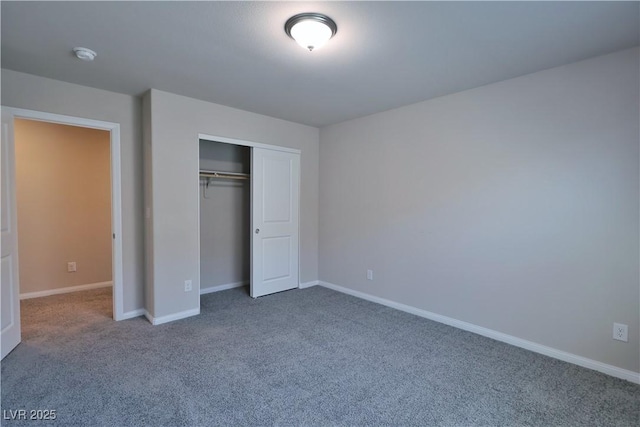 unfurnished bedroom featuring carpet floors, baseboards, and a closet