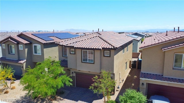 mediterranean / spanish-style home featuring a garage, stucco siding, driveway, and a tile roof