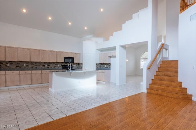 787 Craigmark Ct, Henderson, NV 89002 - kitchen with black microwave, light brown cabinets, decorative backsplash, a sink, and light tile patterned floors