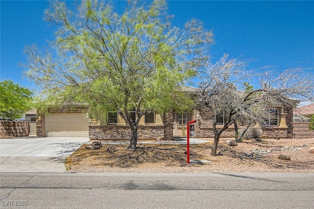 3910 Internet Ave, North Las Vegas, NV 89031 - view of property hidden behind natural elements featuring stone siding, a garage, and concrete driveway