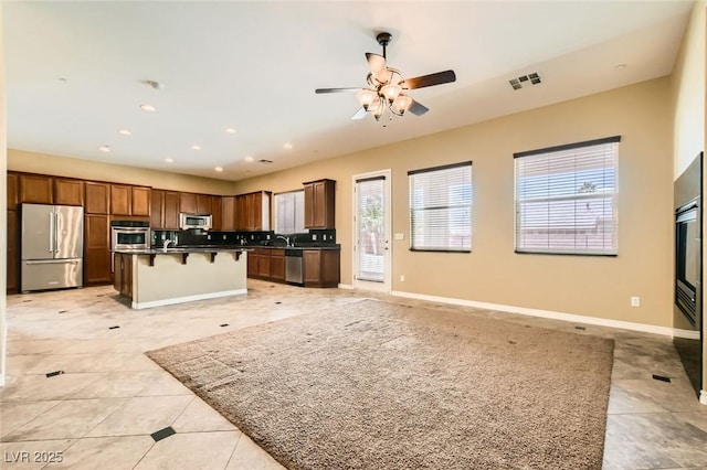 3910 Internet Ave, North Las Vegas, NV 89031 - kitchen with appliances with stainless steel finishes, open floor plan, light tile patterned flooring, a breakfast bar, and ceiling fan