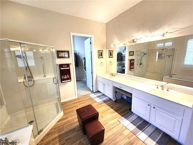 2809 Winslow Springs Dr, Henderson, NV 89052 - bathroom with wood finished floors, a shower stall, double vanity, a walk in closet, and baseboards