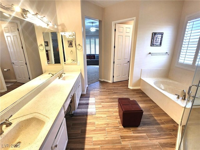 2809 Winslow Springs Dr, Henderson, NV 89052 - full bath featuring double vanity, a garden tub, wood finished floors, baseboards, and a ceiling fan