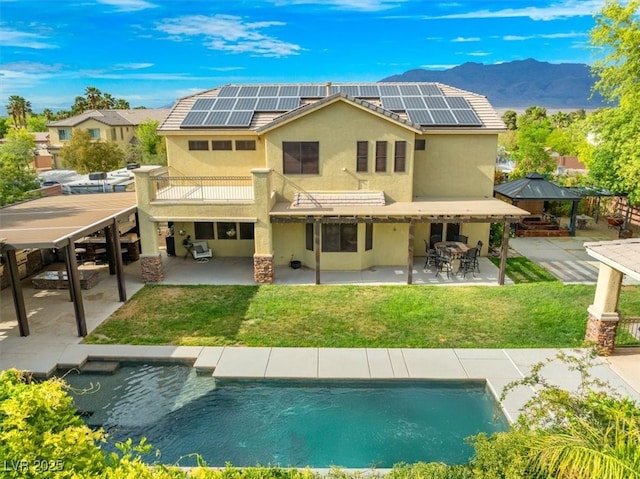 6335 Iginlas Goal Ave, Las Vegas, NV 89131 - back of house with a gazebo, stucco siding, outdoor dining area, solar panels, and a patio