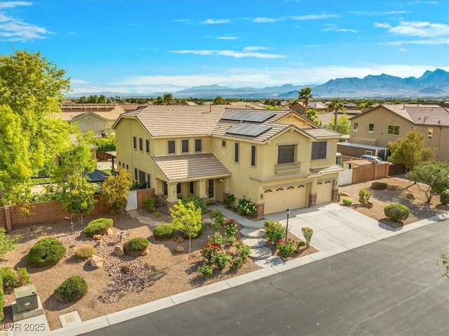 6335 Iginlas Goal Ave, Las Vegas, NV 89131 - traditional-style home featuring a garage, fence, stucco siding, roof mounted solar panels, and driveway