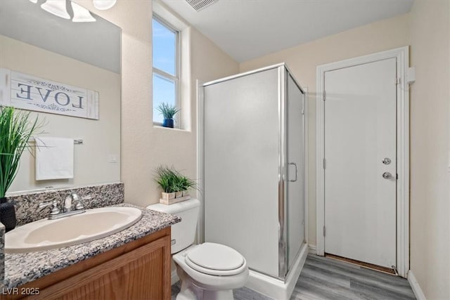 6335 Iginlas Goal Ave, Las Vegas, NV 89131 - bathroom featuring vanity, a shower stall, toilet, and wood finished floors