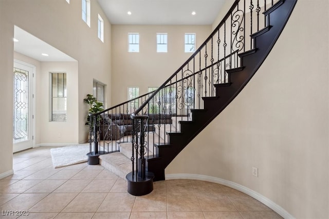 6335 Iginlas Goal Ave, Las Vegas, NV 89131 - stairway with plenty of natural light, a high ceiling, baseboards, and tile patterned flooring