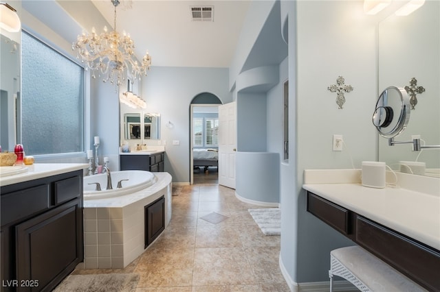 ensuite bathroom with visible vents, connected bathroom, a bath, a chandelier, and a sink