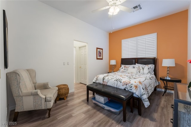 bedroom featuring baseboards, ceiling fan, wood finished floors, and visible vents