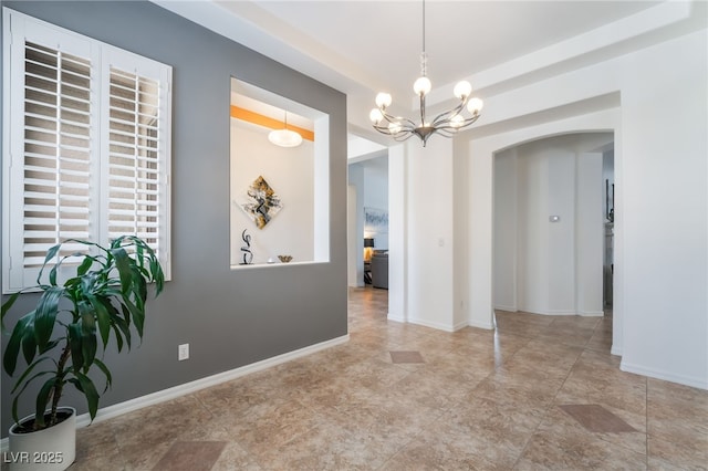 dining space featuring arched walkways, baseboards, and a notable chandelier