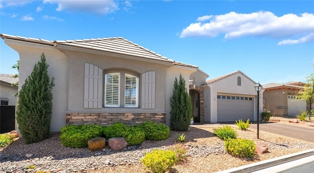 ranch-style home with a garage, stucco siding, driveway, and stone siding
