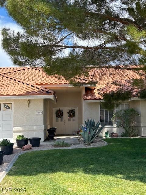 7650 Butterscotch Ct, Las Vegas, NV 89131 - view of front of property featuring a tile roof, a front lawn, and stucco siding
