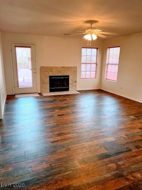 7650 Butterscotch Ct, Las Vegas, NV 89131 - unfurnished living room featuring a ceiling fan, dark wood finished floors, and a tiled fireplace