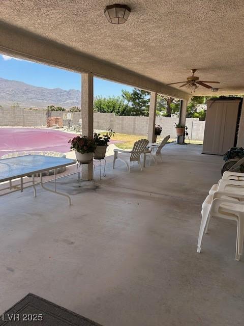 7650 Butterscotch Ct, Las Vegas, NV 89131 - fenced backyard featuring a mountain view, a patio area, and ceiling fan