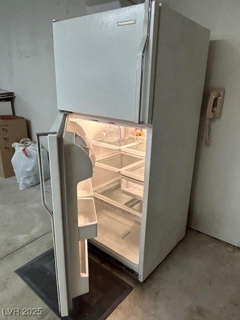 7650 Butterscotch Ct, Las Vegas, NV 89131 - kitchen view of freestanding refrigerator and unfinished concrete floors