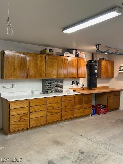 7650 Butterscotch Ct, Las Vegas, NV 89131 - kitchen with brown cabinets, concrete floors, light countertops, and water heater