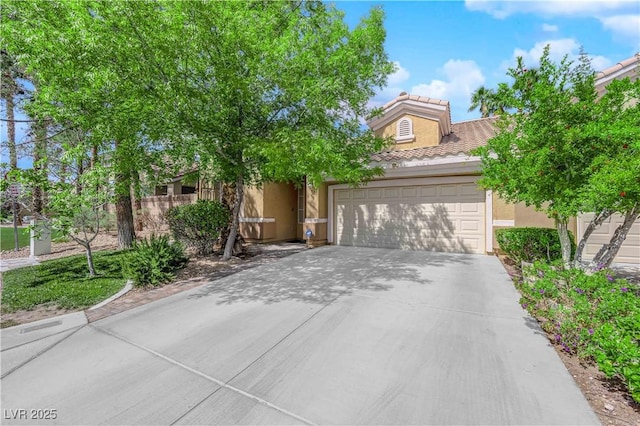 view of front of property with fence, an attached garage, a tile roof, stucco siding, and driveway