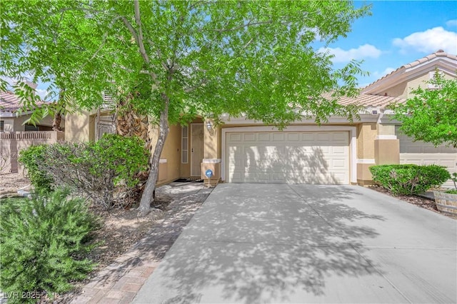 obstructed view of property featuring a garage, stucco siding, and driveway