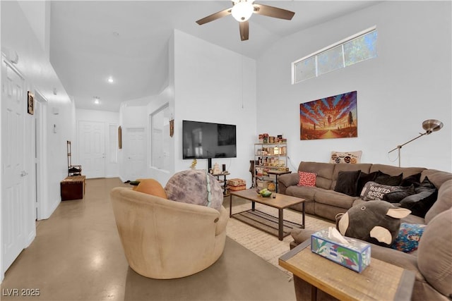 living room featuring high vaulted ceiling, ceiling fan, baseboards, and finished concrete floors