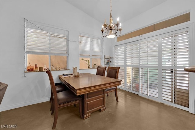 dining room featuring baseboards, an inviting chandelier, lofted ceiling, and finished concrete flooring