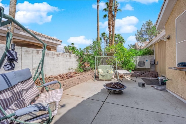 view of patio / terrace featuring a fenced backyard, ac unit, and a fire pit