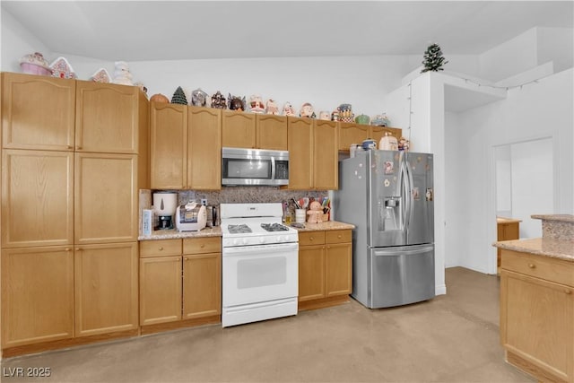 kitchen featuring light brown cabinetry, appliances with stainless steel finishes, decorative backsplash, and light stone countertops