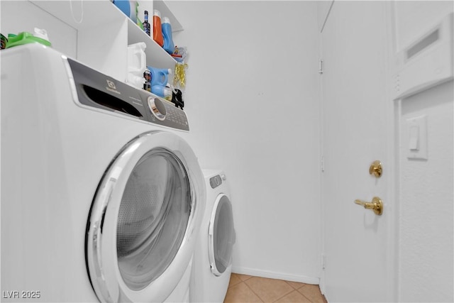 laundry area featuring laundry area, light tile patterned floors, and washing machine and clothes dryer