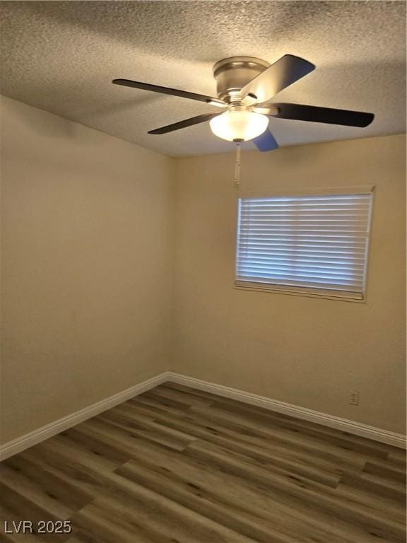 spare room with baseboards, ceiling fan, dark wood-style flooring, and a textured ceiling