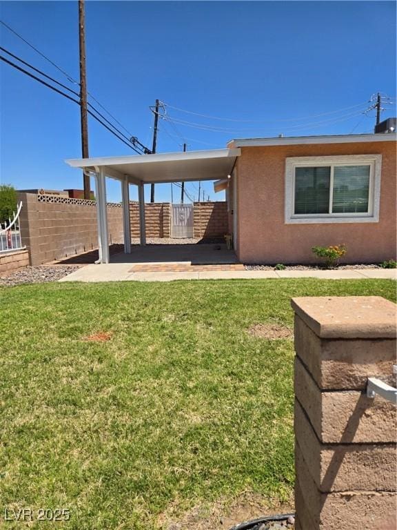 rear view of house featuring a lawn and fence