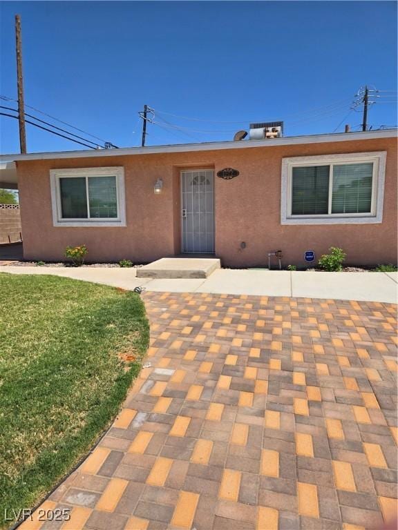 single story home featuring a patio, stucco siding, a front yard, and fence
