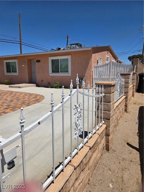 ranch-style house with stucco siding and fence