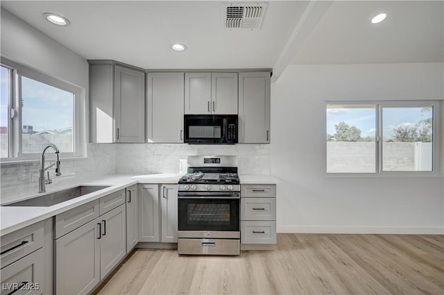 4419 Fairmont Cir, Las Vegas, NV 89147 - kitchen featuring gray cabinets, visible vents, black microwave, a sink, and stainless steel gas range