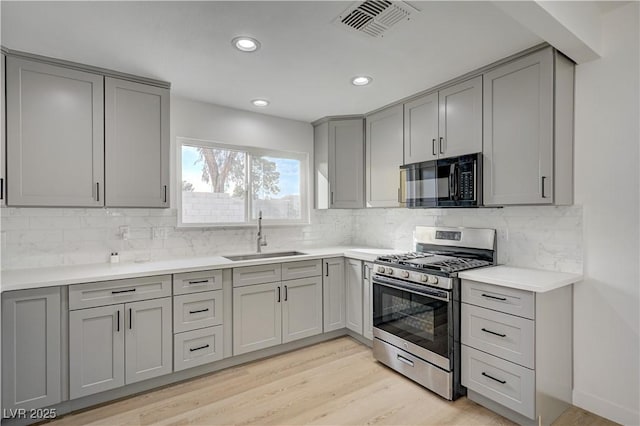 4419 Fairmont Cir, Las Vegas, NV 89147 - kitchen with visible vents, black microwave, gas stove, gray cabinetry, and a sink