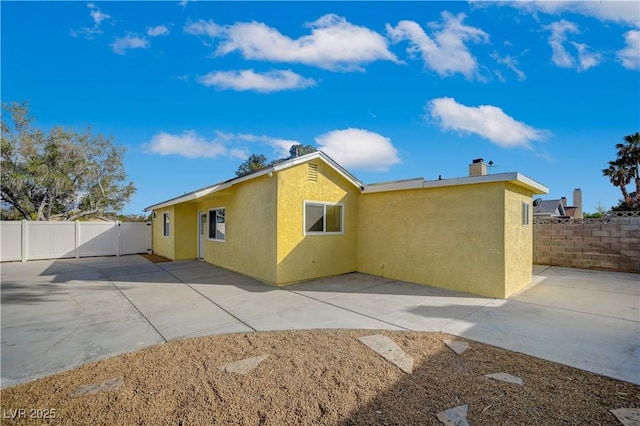 4419 Fairmont Cir, Las Vegas, NV 89147 - rear view of property featuring a patio, a fenced backyard, stucco siding, and a chimney