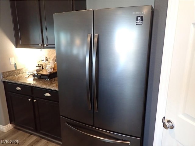 4361 Duck Harbor Ave, North Las Vegas, NV 89031 - kitchen with freestanding refrigerator, stone counters, and light wood finished floors