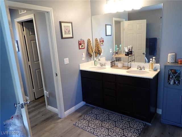 4361 Duck Harbor Ave, North Las Vegas, NV 89031 - bathroom featuring double vanity, a sink, and wood finished floors