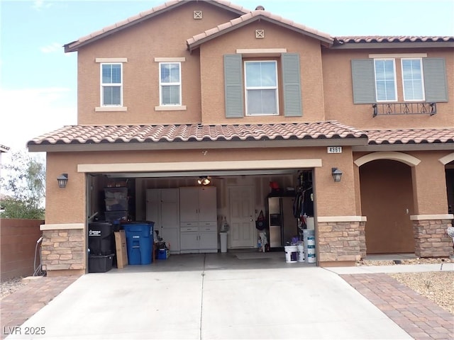 4361 Duck Harbor Ave, North Las Vegas, NV 89031 - mediterranean / spanish home featuring a tiled roof, a garage, driveway, and stone siding